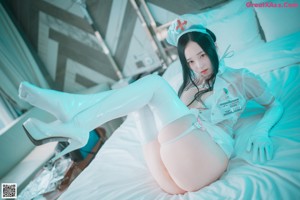 A woman dressed as a nurse is posing for a picture.