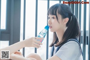 A couple of young women in school uniforms kissing each other.