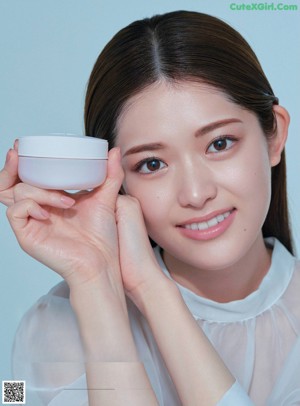 A magazine page with a picture of a woman's face and a bottle of cream.