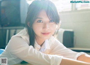 A woman in a school uniform leaning against a window.