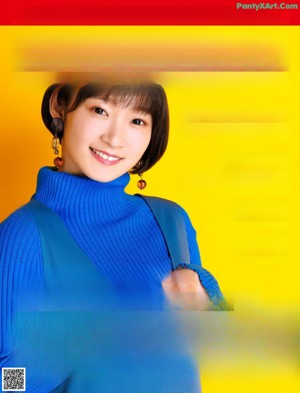 A woman in a blue turtle neck sweater posing for a picture.