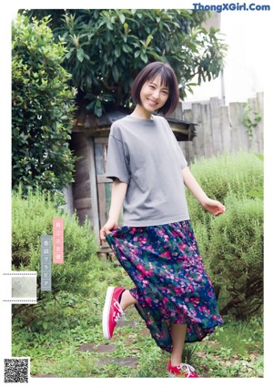 A woman in a white shirt is posing for a magazine.