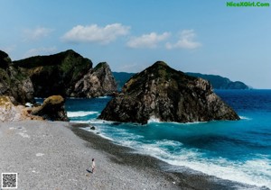 A naked woman sitting on a rock in the water.