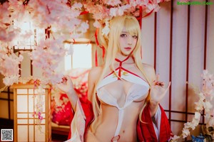 A woman in a red and white lingerie sitting on a bed.