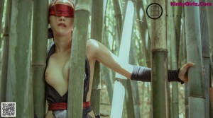 A naked woman standing in a bamboo forest.