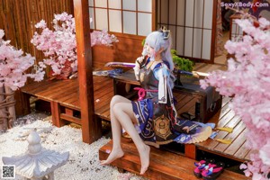 A woman sitting on a wooden bench holding a fan.