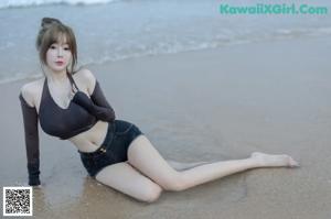 A woman standing in the water at the beach.