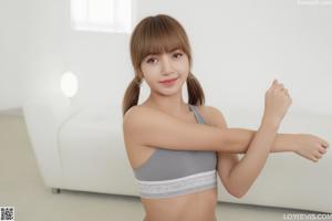 A woman in a red bra and panties posing on a bed.