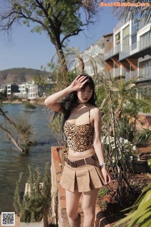 A woman sitting on a wooden deck next to the ocean.