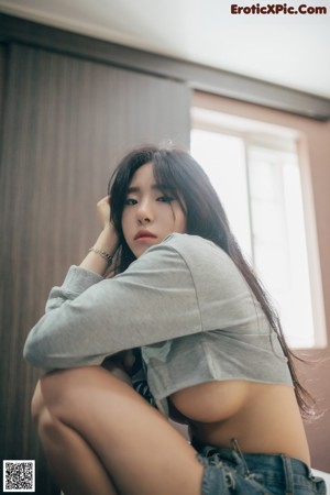 A woman laying on top of a bed in a white underwear.