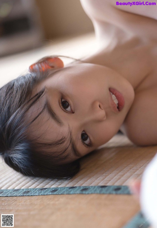A little girl laying on the floor looking at the camera.