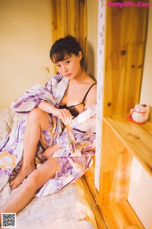 A woman in a black lingerie holding a bouquet of flowers.