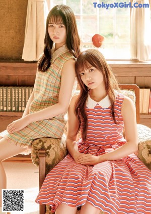 Two young women in school uniforms standing next to each other.