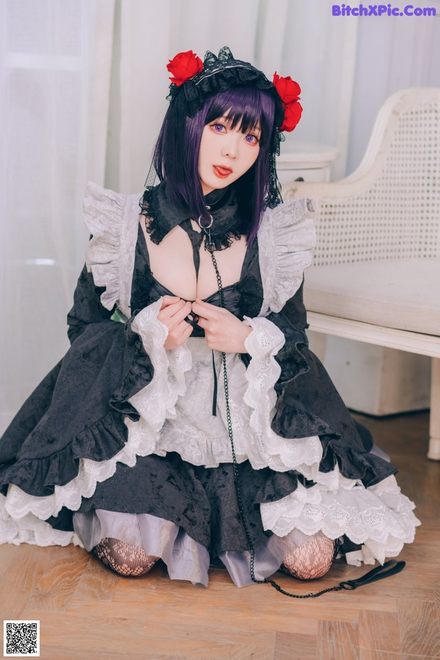 A woman in a black and white dress sitting on the floor.