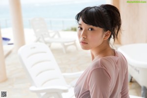 A woman in a pink shirt is sitting in a bathtub.