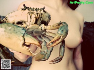 A naked woman holding a stuffed animal in her hands.