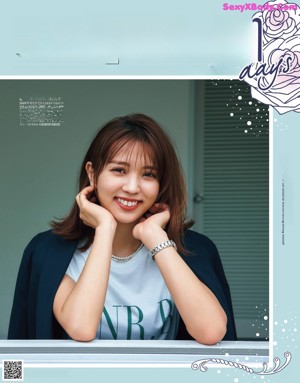 A woman in a white shirt and white pants is posing for a magazine.