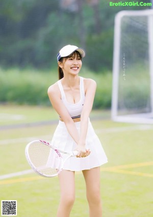 A woman holding a tennis racket and a tennis ball.