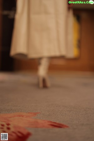 A woman in a white jacket and white boots posing for a picture.