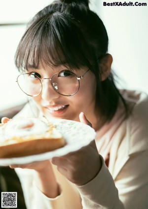 A young woman wearing a white shirt and glasses.