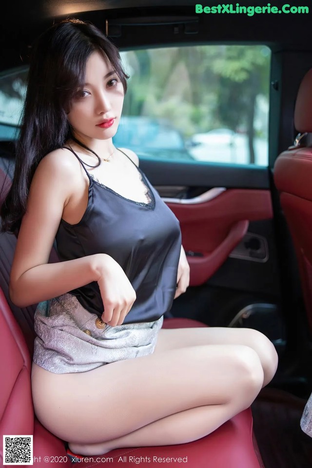 A woman sitting in the back seat of a car.