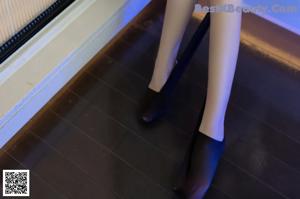 A woman in a white shirt and black lingerie sitting on a dresser.