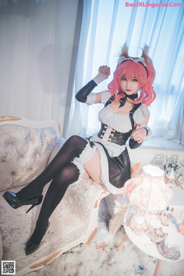 A woman sitting on top of a couch next to a table.