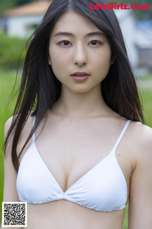 A woman in a white bikini posing for a picture.