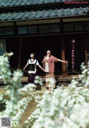 Two young women sitting on a bench in a room.