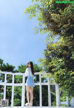 A woman in a white dress walking through a field.