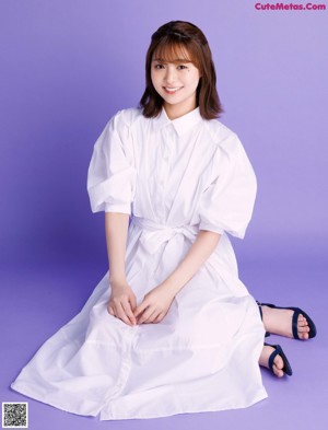 A woman in a white shirt is posing for a magazine.