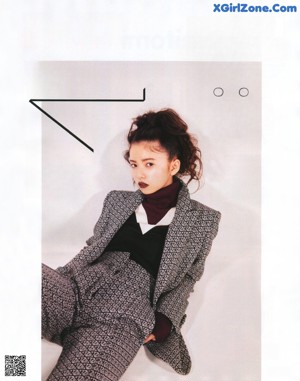 A magazine page with a picture of a woman wearing a cat mask.