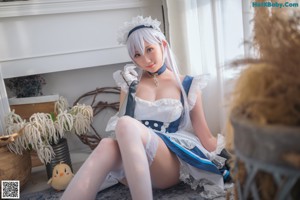 A woman dressed in a maid outfit holding a broom.