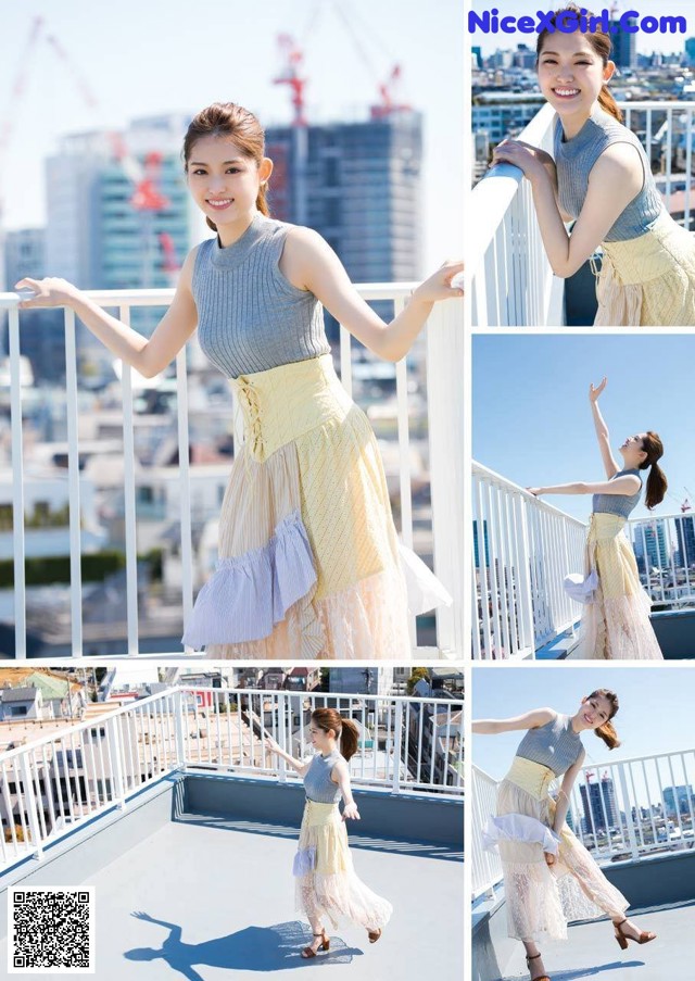 A woman standing on top of a building with her arms outstretched.