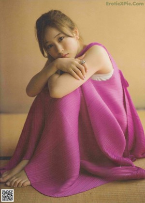 A woman in a white dress is posing for a magazine.