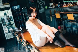 A woman sitting at a bar in a restaurant.