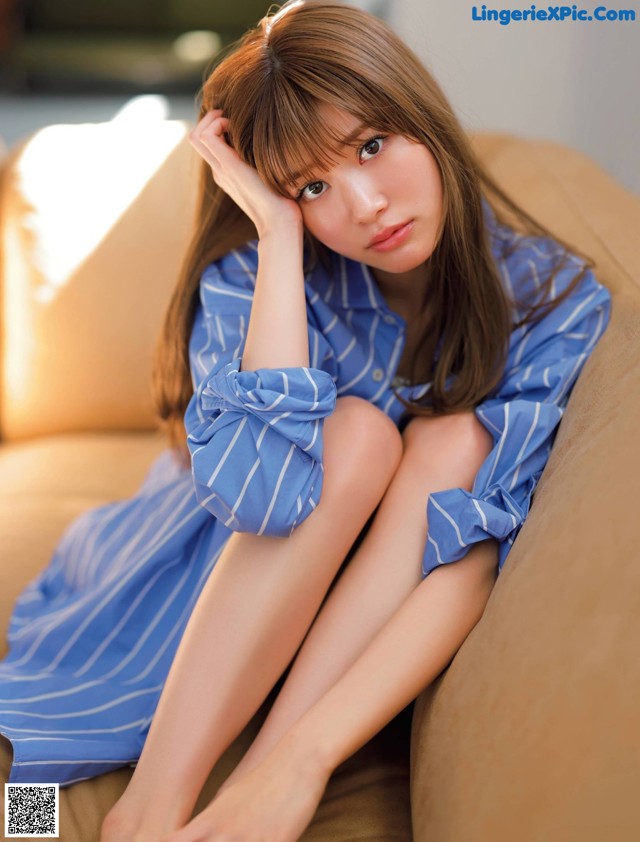 A woman sitting on a couch with her legs crossed.