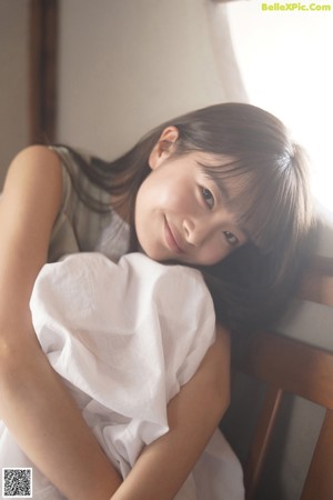 A woman in a white dress sitting on the floor.