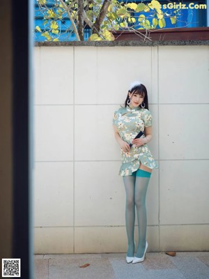 A woman in a white bra and blue stockings posing for a picture.
