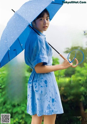 A woman in a blue dress holding an umbrella.