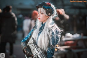 A woman with long white hair wearing a helmet and gloves.