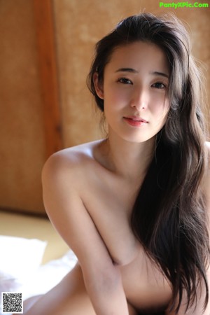 A woman in a white bra and panties posing for a picture.