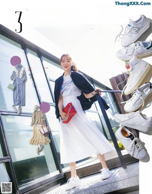 A woman in a white dress talking on a cell phone.